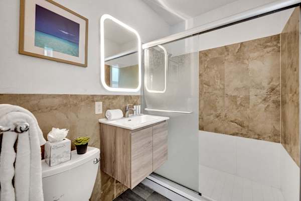 Modern bathroom with LED mirror and glass shower