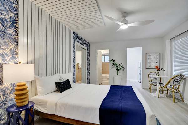 King bedroom with tropical wallpaper and desk