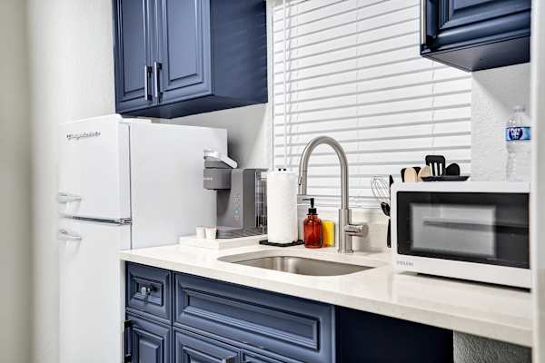 Navy blue kitchenette with sink and microwave
