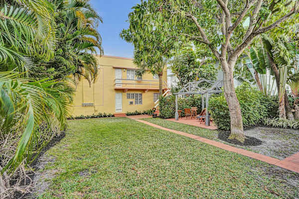 Charming yellow building exterior with lush lawn