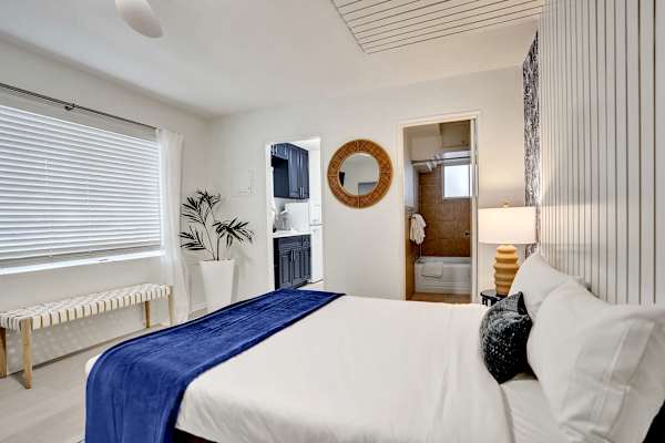 Queen bed with crisp white linens and natural light