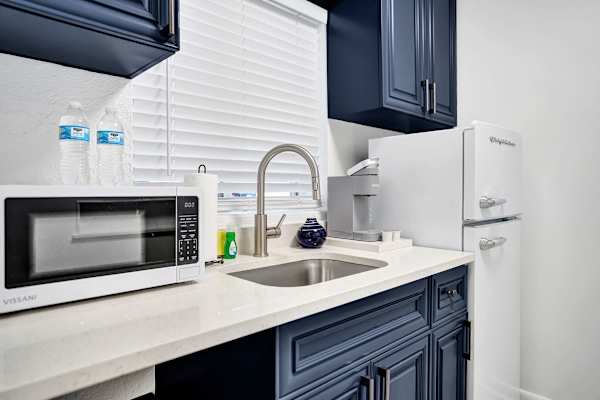 Compact kitchenette with navy cabinets and appliances