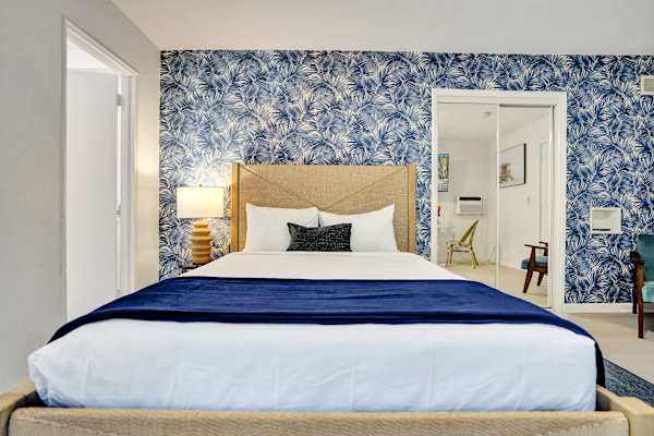 King bed with crisp white linens and accent wall