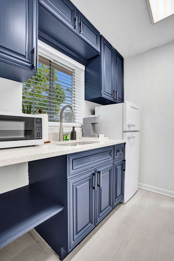 Navy kitchen cabinets with marble-look countertop