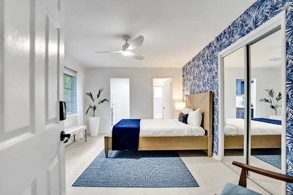 King bedroom with bold blue botanical wallpaper