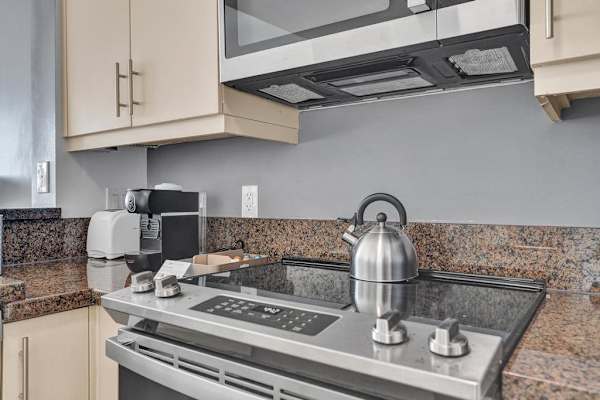 Gas stove with kettle and granite backsplash