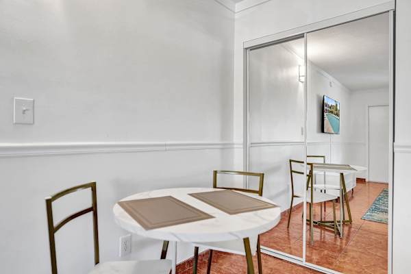 Compact dining table with mirrored closet backdrop