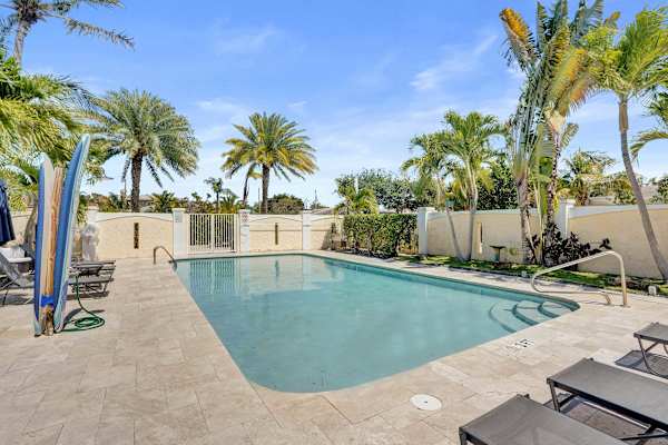 Outdoor pool with surfboard and tropical palms
