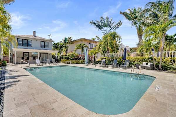 Full pool view with building and lounge chairs