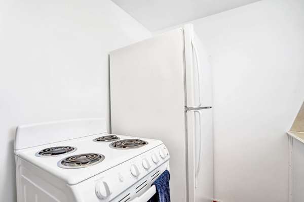 Full-size stove and refrigerator in white kitchen