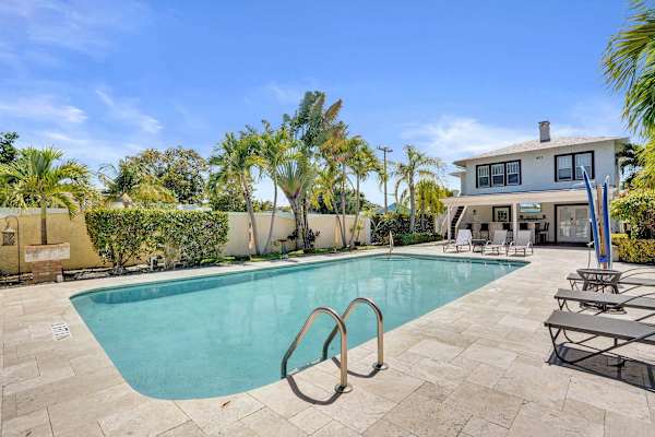 Pool entry steps with sunny patio and palms