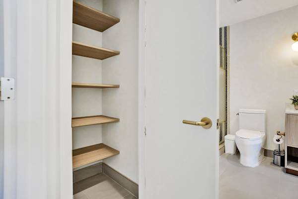 Built-in linen shelving and bathroom access
