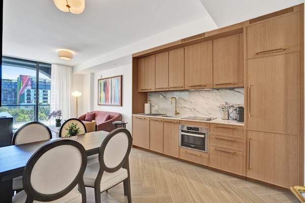 Kitchen open to dining with warm wood cabinetry