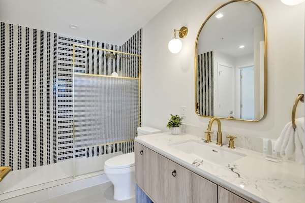 Full bathroom with designer tile and gold accents