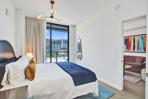King bedroom with balcony access and city views