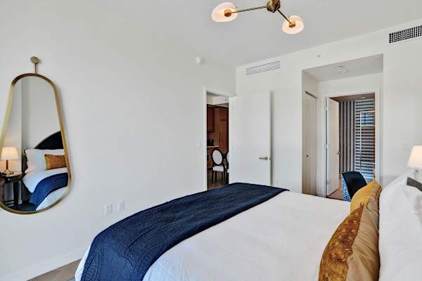 King bedroom with soft lighting and navy bedding