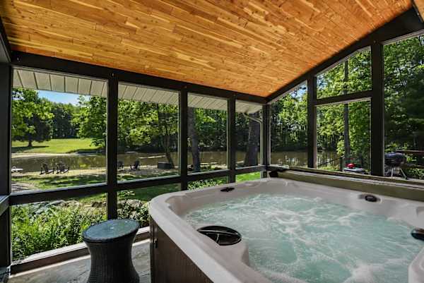 Covered hot tub overlooking the beach and swim pond.  