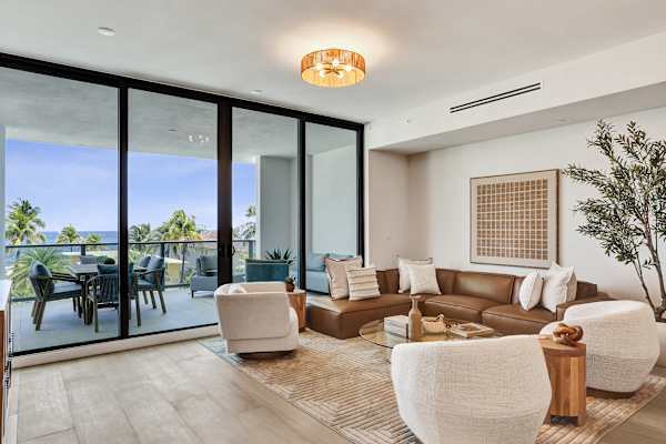 Sunlit living room with balcony and ocean view