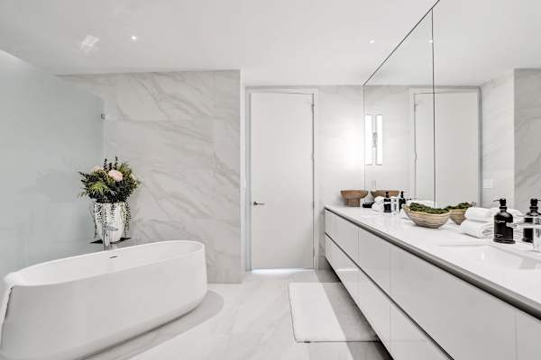 En-suite with freestanding tub and marble walls