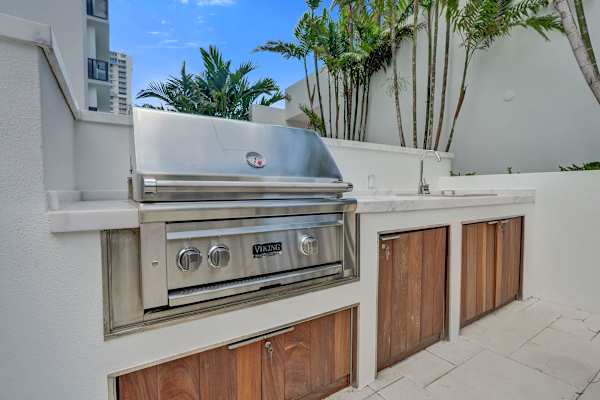 Outdoor built-in stainless steel grill with storage cabinets