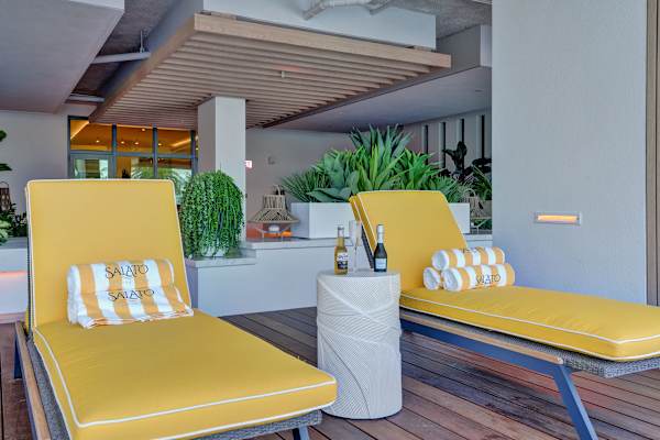 Two yellow lounge chairs by the pool area