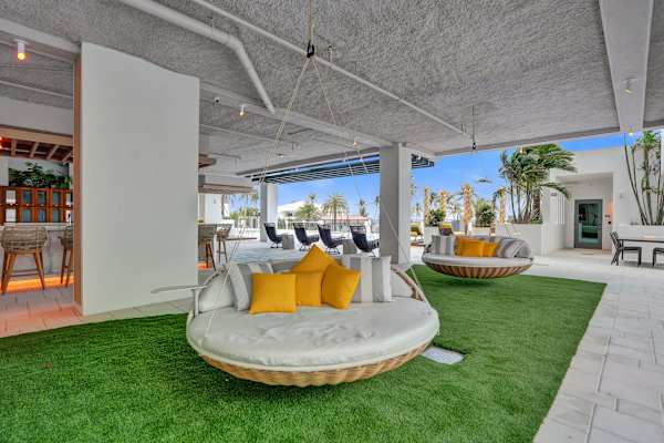 Round outdoor daybed with yellow pillows on lawn