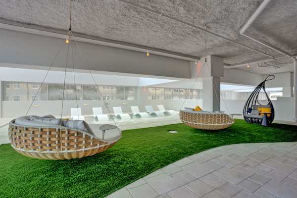Round outdoor daybed with pillows on lawn