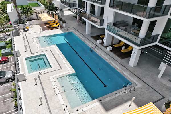 Outdoor pool and hot tub with lounge chairs