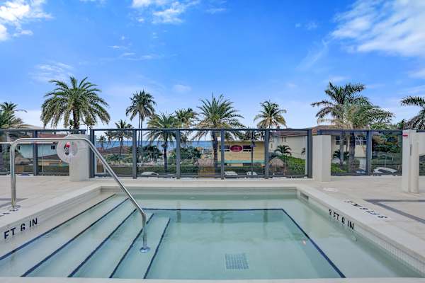 Outdoor hot tub with palm trees and ocean views
