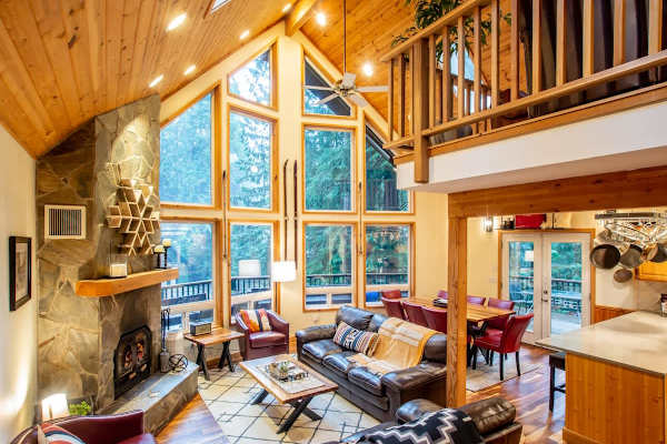 Relax in the living room with vaulted ceilings and wood burning fireplace. Our place has great views of the trees and has the perfect open layout for togetherness. 