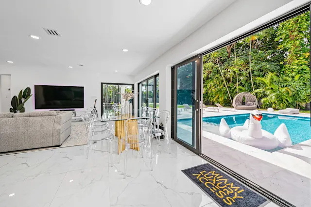 Open living and dining room with sliding doors to the pool