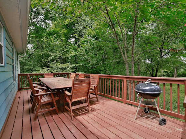 Side deck with barbecue grill and outdoor seating.