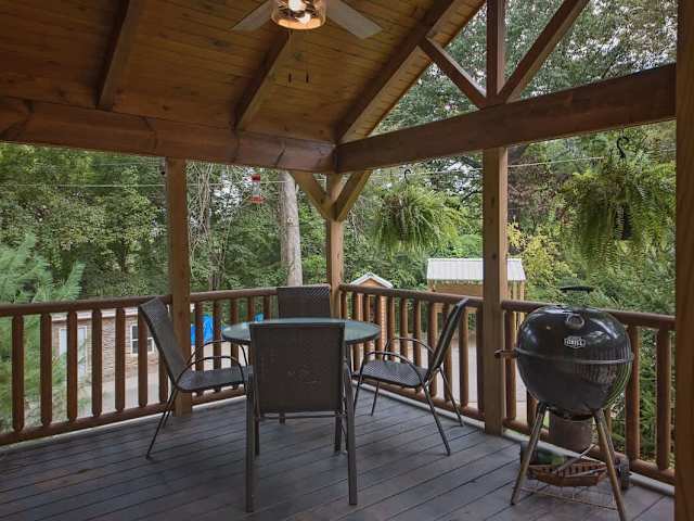 Covered front porch with barbecue grill and outdoor seating.