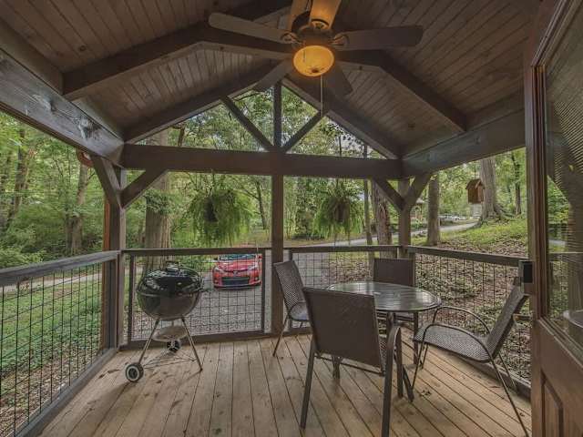 Covered front porch with barbecue grill and outdoor furniture.