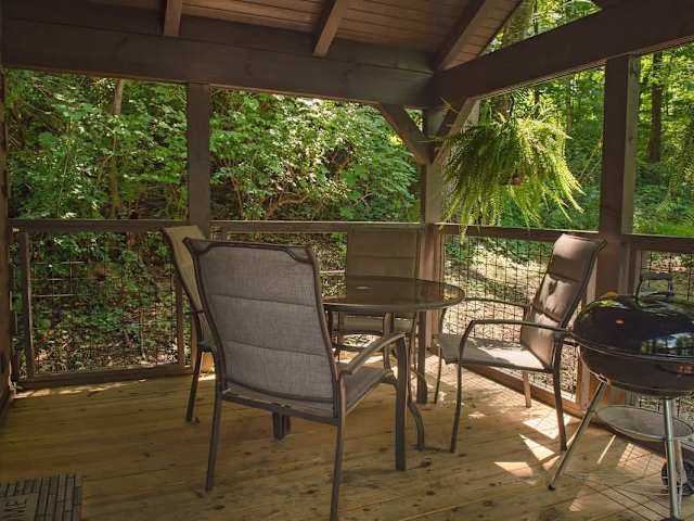 Covered front porch with barbecue grill and outdoor seating