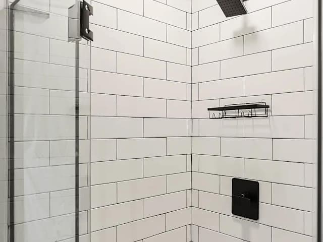 Modern walk-in shower with tile walls and sleek fixtures, offering a refreshing space to unwind after the day’s adventures.