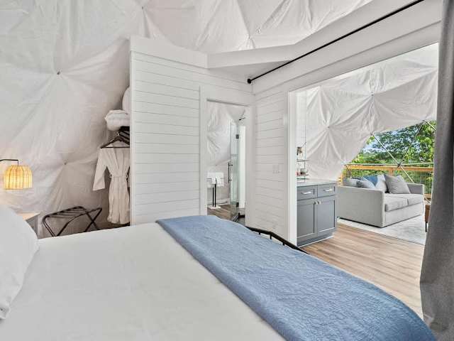 Restful queen bed with soft linens inside the dome, designed for cozy nights after lake or trail adventures.