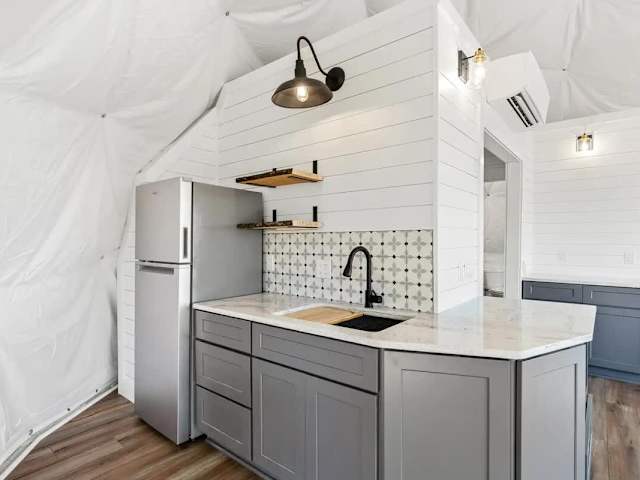 Compact kitchenette with sink, counter space, and stylish finishes, designed for simple meal prep during your stay.