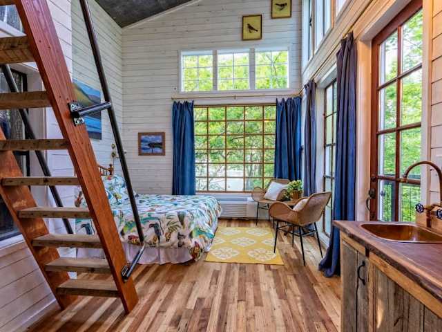 The interior features a queen bed on the main floor with extra sleeping arrangements in the loft.