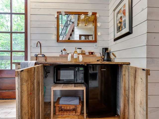 The microwave, mini fridge, and a picnic basket are inside the cabinets