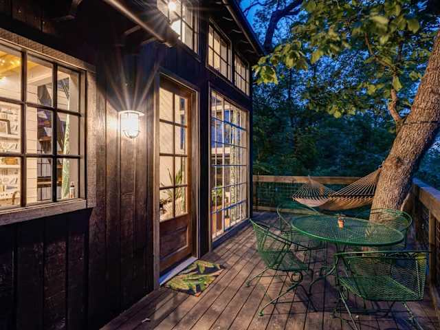 The wrap around deck with a table, chairs, and hammock