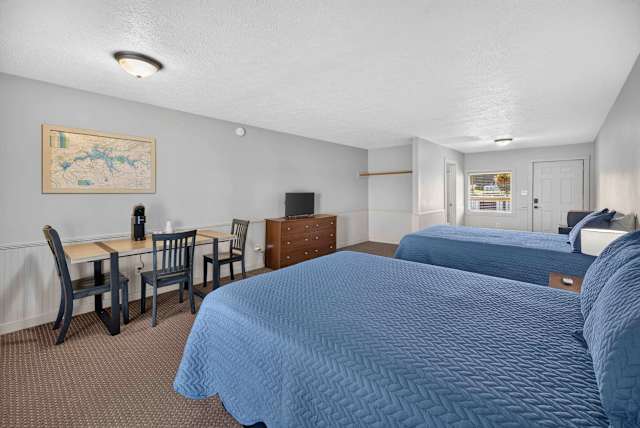 Coffee maker, TV, dresser, two queen beds, & table with chairs