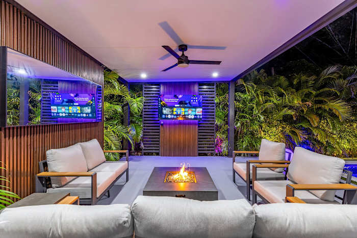Covered lounge area with XL Smart TV and a firepit