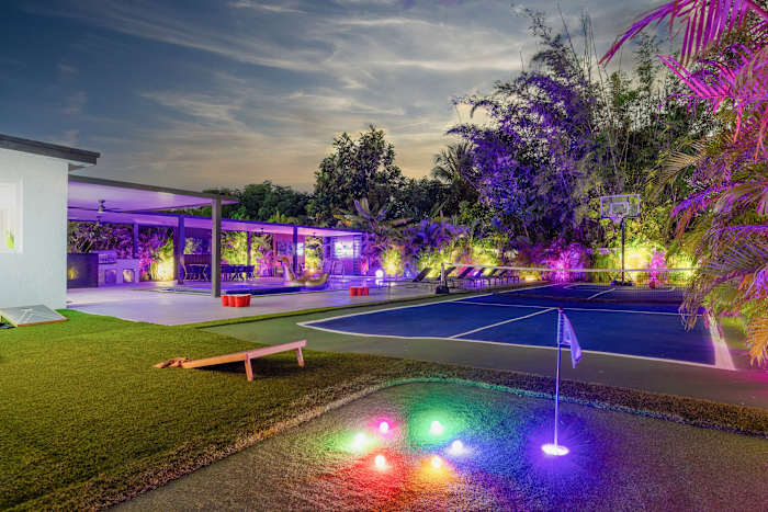 Lit-up backyard for dining and entertainment.