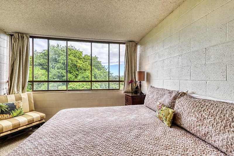 Primary bedroom overlooking lush greenery