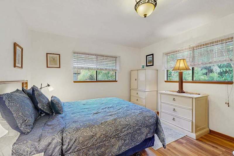 Bedroom View Facing Dressers, Large Windows & Bedside Setup