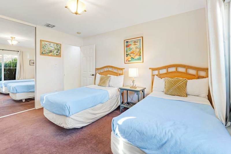 Guest room with two single beds and a flat screen tv.