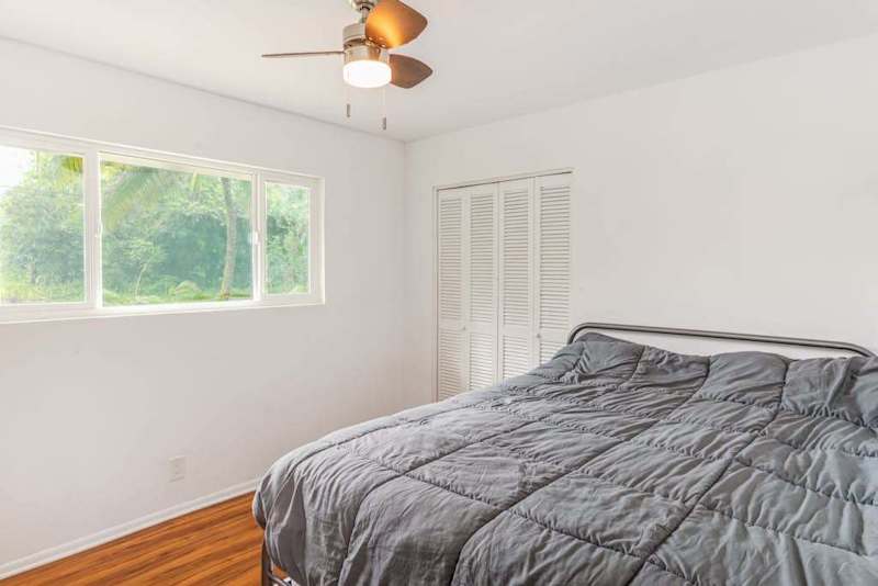 Master bedroom with queen bed and lots of light from the windows.