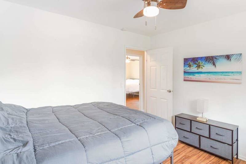 Master bedroom with queen bed and lots of light from the windows.