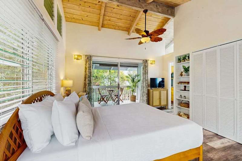 Bedroom provides restful sleeping space with ceiling fan and windows